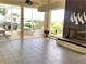 Bright sunroom features tile flooring, a fireplace, and views of outdoor picnic area and greenery at 401 Windrush Bay Dr, Tarpon Springs, FL 34689