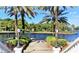 Picturesque waterfront walkway with decorative plants and views of the calm water at 401 Windrush Bay Dr, Tarpon Springs, FL 34689