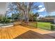 Large wooden deck with built-in seating overlooking the landscaped backyard at 412 Mira Vista Dr, Dunedin, FL 34698