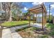 Well-designed backyard with a pergola, concrete walkway, and a storage shed for functional outdoor enjoyment at 412 Mira Vista Dr, Dunedin, FL 34698