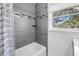 Stylish bathroom features gray tile, mosaic accents, a bathtub and a window at 412 Mira Vista Dr, Dunedin, FL 34698