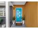 Stylish front entrance features a bright blue door with unique window accents and potted plants at 412 Mira Vista Dr, Dunedin, FL 34698