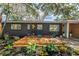 Inviting front yard with cozy deck seating area, complemented by beautiful landscaping and a modern design at 412 Mira Vista Dr, Dunedin, FL 34698