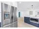 Bright kitchen with stainless steel refrigerator, blue cabinets, white counters, and light wood-look floors at 412 Mira Vista Dr, Dunedin, FL 34698