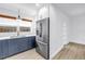 Kitchen showcasing stainless steel refrigerator, blue cabinets, white countertops and light wood-look floors at 412 Mira Vista Dr, Dunedin, FL 34698