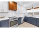 Contemporary kitchen features stainless steel appliances and blue base cabinetry with white upper cabinets at 412 Mira Vista Dr, Dunedin, FL 34698