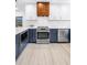 Modern kitchen featuring stainless appliances and blue base cabinetry with white upper cabinets at 412 Mira Vista Dr, Dunedin, FL 34698