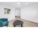 Bright living room with wood-look floors, neutral walls, and a comfortable blue accent chair at 412 Mira Vista Dr, Dunedin, FL 34698