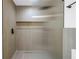 Close-up of glass shower featuring gray tile surround with black hardware and fixtures at 412 Mira Vista Dr, Dunedin, FL 34698