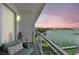 Enjoy stunning waterfront views from this cozy balcony with comfortable seating and modern glass railings at 415 Island Way # 507, Clearwater Beach, FL 33767