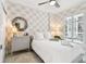 Inviting bedroom with stylish wallpaper, plantation shutters, and a comfortable bed at 415 Island Way # 507, Clearwater Beach, FL 33767