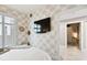 Serene bedroom with stylish wallpaper, plantation shutters, and flat screen tv at 415 Island Way # 507, Clearwater Beach, FL 33767