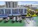 Beautiful waterfront building with boat slips, featuring manicured landscaping, serene views, and modern architecture at 415 Island Way # 507, Clearwater Beach, FL 33767