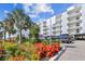 Modern condominium featuring lush landscaping, ample parking, and a sleek white exterior design at 415 Island Way # 507, Clearwater Beach, FL 33767