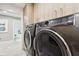 Updated laundry area with front loading machines, modern cabinets and view of bathroom at 415 Island Way # 507, Clearwater Beach, FL 33767