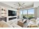 Living room with a fan, TV, and view of the water from the balcony at 415 Island Way # 507, Clearwater Beach, FL 33767