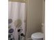 Bathroom features a toilet next to a tub with a decorative shower curtain at 4206 Revere Cir, New Port Richey, FL 34653