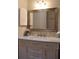 Bathroom vanity with marble countertop, decorative mirror, and white cabinets at 4206 Revere Cir, New Port Richey, FL 34653