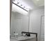 Bathroom featuring a double sink vanity, a large mirror with light fixtures, and white cabinets at 4206 Revere Cir, New Port Richey, FL 34653
