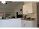 Kitchen with white cabinets, vaulted ceiling, and view to the living room at 4206 Revere Cir, New Port Richey, FL 34653