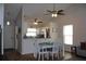 Bright living area open to kitchen features wood floors, a ceiling fan and white kitchen cabinets at 4206 Revere Cir, New Port Richey, FL 34653