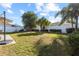 Spacious backyard with lush green grass, palm trees and a white fence at 4510 Beaumaris Dr, Land O Lakes, FL 34638