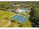Aerial view of a green field with two basketball courts and a community pool in the background at 4510 Beaumaris Dr, Land O Lakes, FL 34638