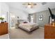 Comfortable bedroom featuring a ceiling fan, neutral tones, and an ensuite bathroom with an arched window at 4510 Beaumaris Dr, Land O Lakes, FL 34638