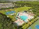 Aerial view of the community pool featuring a lounge area, and a splash pool, all surrounded by lush trees at 4510 Beaumaris Dr, Land O Lakes, FL 34638