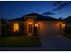Inviting home exterior at twilight, featuring a two-car garage and manicured lawn at 4510 Beaumaris Dr, Land O Lakes, FL 34638
