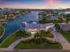 Stunning aerial view of waterfront estate featuring lush landscaping, circular drive, and beautiful views at 511 Windward Psge, Clearwater Beach, FL 33767