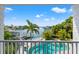 Balcony view of waterfront property with a private pool, dock, and lush landscaping at 511 Windward Psge, Clearwater Beach, FL 33767