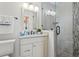 Bright bathroom with a glass enclosed shower, modern lighting, and a granite countertop vanity at 511 Windward Psge, Clearwater Beach, FL 33767
