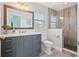 Well-lit bathroom showcasing a modern vanity, framed mirror, and a tiled shower with glass door at 511 Windward Psge, Clearwater Beach, FL 33767