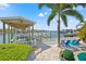 Picturesque boat dock with a covered boat lift, lush landscaping, and waterfront access for nautical enthusiasts at 511 Windward Psge, Clearwater Beach, FL 33767