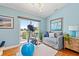 Bright exercise room with a stationary bike, sofa, and balcony access offering scenic views at 511 Windward Psge, Clearwater Beach, FL 33767