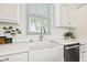 Bright kitchen featuring a farmhouse sink, marble countertops, and subway tile backsplash at 511 Windward Psge, Clearwater Beach, FL 33767