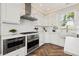 Gourmet kitchen with white cabinets, herringbone floors, and stainless steel appliances at 511 Windward Psge, Clearwater Beach, FL 33767