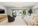 Bright living room with a crystal chandelier and views of the pool and water at 511 Windward Psge, Clearwater Beach, FL 33767