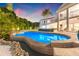 Beautiful backyard pool with lush tropical landscaping, custom stone edging, and a spacious patio for outdoor living at 511 Windward Psge, Clearwater Beach, FL 33767