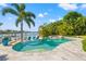Serene pool view featuring lush tropical landscaping, inviting seating, and convenient dock access to the waterfront at 511 Windward Psge, Clearwater Beach, FL 33767