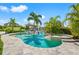 Inviting backyard pool and spa surrounded by palm trees, with seating, and a dock for waterfront access at 511 Windward Psge, Clearwater Beach, FL 33767