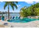 A luxurious backyard featuring a pool, hot tub, and waterfront view surrounded by lush greenery at 511 Windward Psge, Clearwater Beach, FL 33767