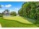 Lush putting green with palm trees, leading to waterfront, perfect for recreation and relaxation at 511 Windward Psge, Clearwater Beach, FL 33767