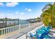 Relaxing waterfront area with comfortable Adirondack chairs, a pristine fence, and a private dock for boats at 511 Windward Psge, Clearwater Beach, FL 33767