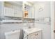 Remodeled bathroom with white tiled walls, toilet, and a vanity with a sink and fixtures at 516 Northmoor N Ave, St Petersburg, FL 33702