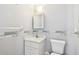 Compact bathroom with a vanity, toilet, medicine cabinet, and decorative wall trim at 516 Northmoor N Ave, St Petersburg, FL 33702