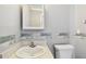 Cozy bathroom featuring a toilet, sink, vanity with cabinet and a wall mirror at 516 Northmoor N Ave, St Petersburg, FL 33702
