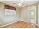 Bright bedroom featuring hardwood floors, a ceiling fan, and a large window with blinds and curtains at 516 Northmoor N Ave, St Petersburg, FL 33702