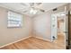 Bright bedroom features hardwood floors, neutral paint, ceiling fan, and natural light from a window at 516 Northmoor N Ave, St Petersburg, FL 33702